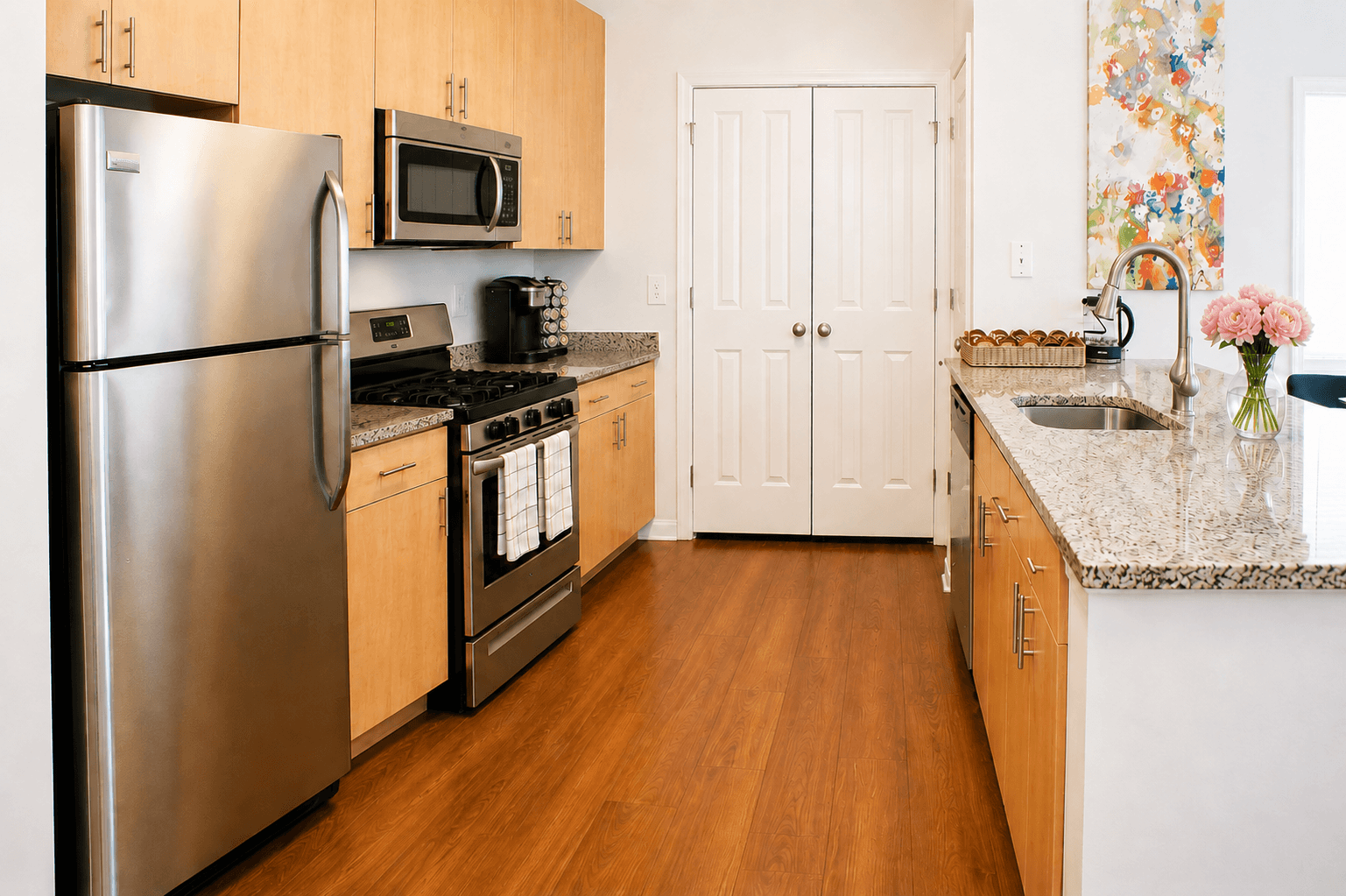 Modern kitchen featuring stainless steel appliances, granite countertops, and wooden cabinets.