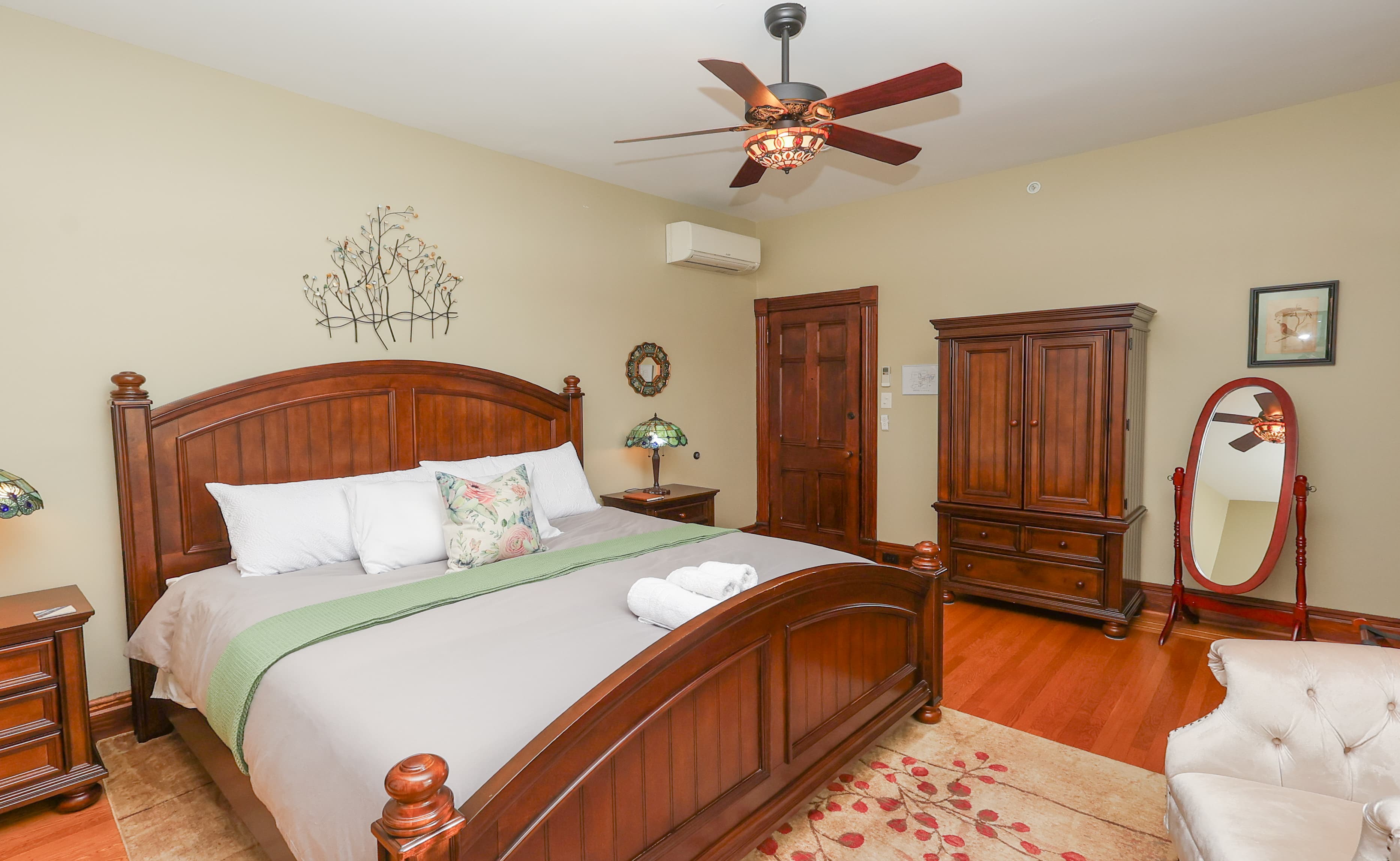A cozy bedroom featuring a wooden bed, elegant furnishings, and warm decor.