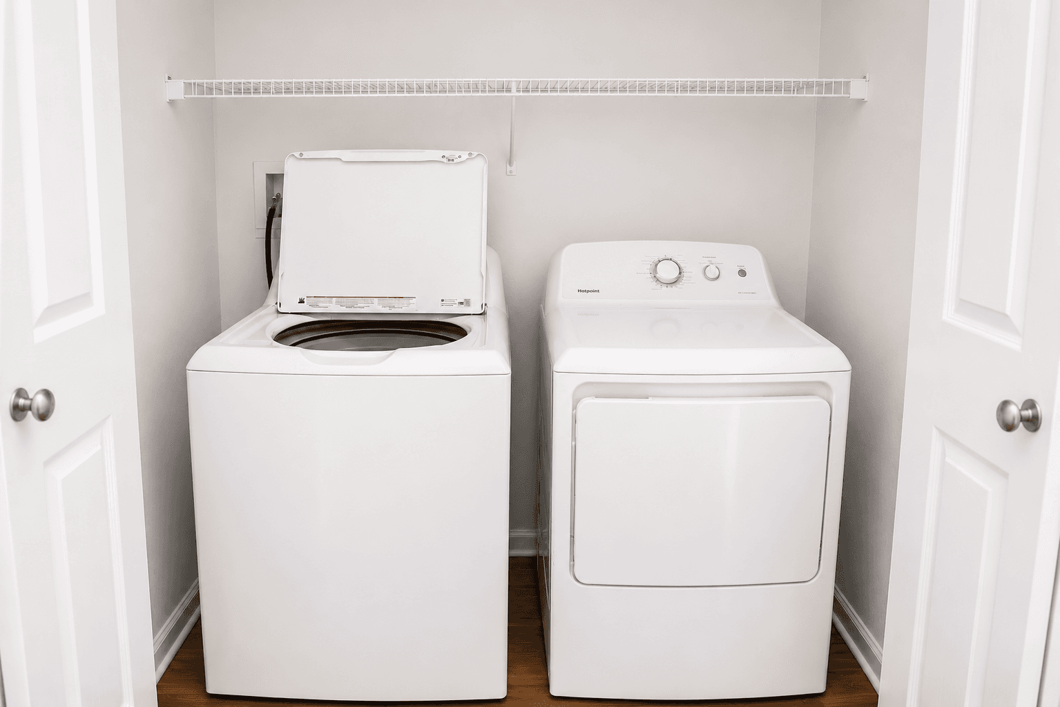 A white washing machine and dryer side by side in a laundry room.